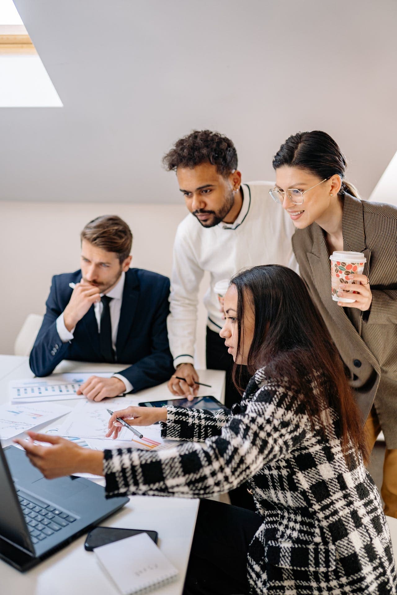 Professionelle Atlassian-Beratung für effiziente Prozesse und Tool-Integration Ein diverses Expertenteam analysiert gemeinsam Daten und Workflows an einem Laptop, um eine professionelle Atlassian-Beratung durchzuführen