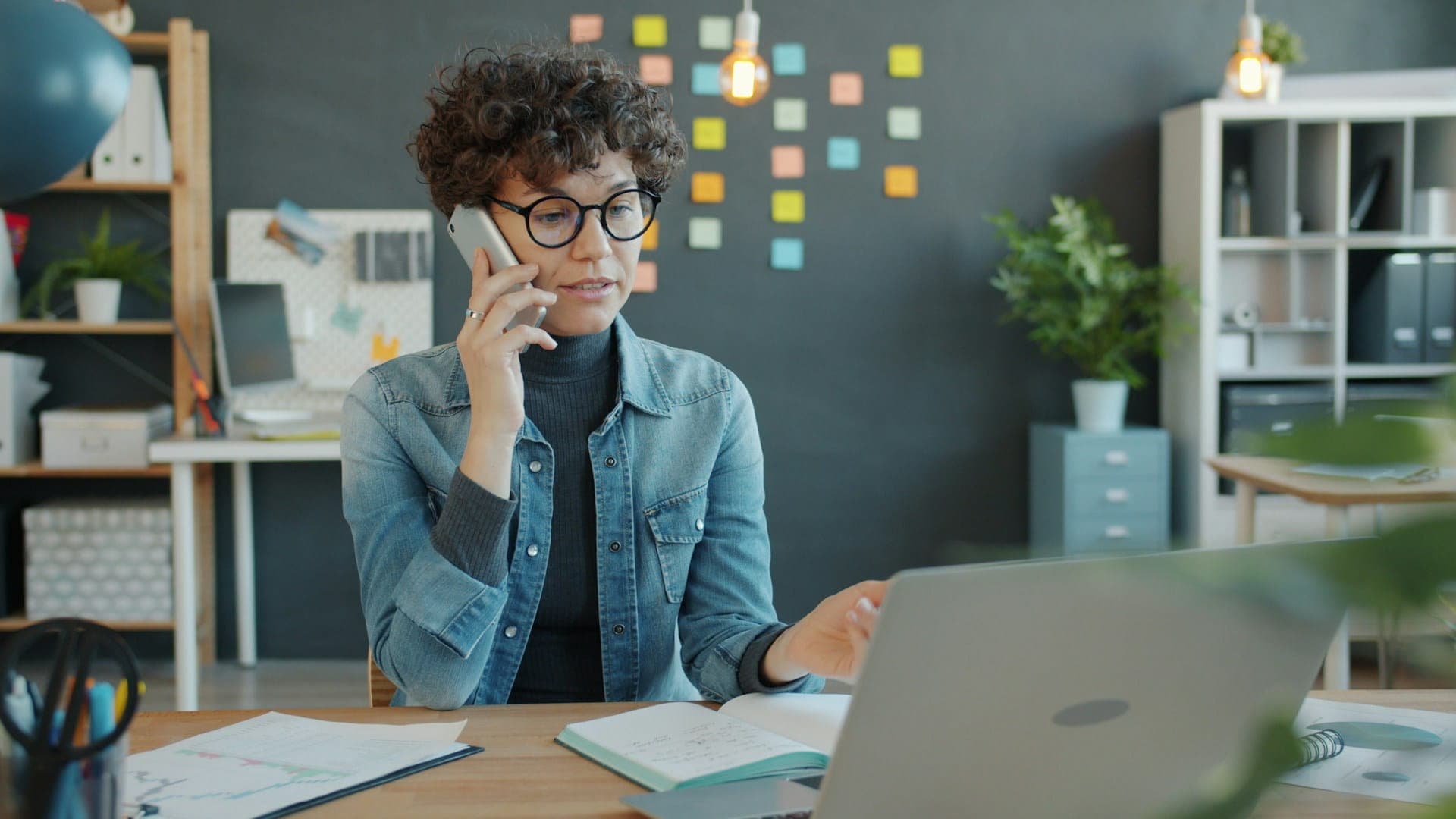 Mitarbeiterin im technischen Atlassian Support am Laptop und Telefon für eine schnelle Lösung von Störungen im Tagesgeschäft Mitarbeiterin im technischen Atlassian Support am Laptop und Telefon für eine schnelle Lösung von Störungen im Tagesgeschäft